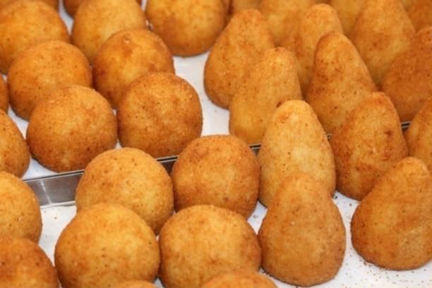 Arancini dorati appena fritti in teglia