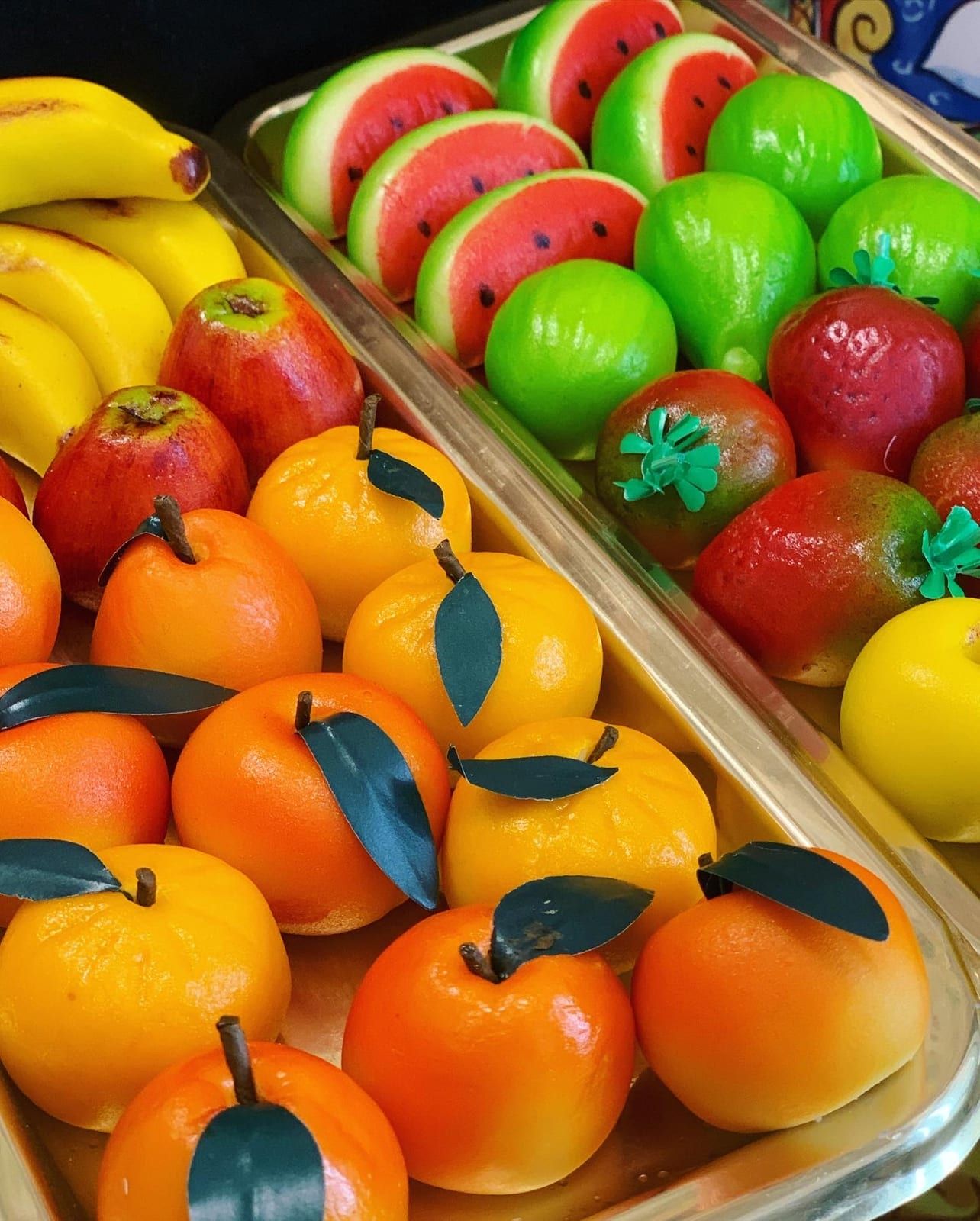 Frutta di marzapane colorata in vetrina: arance, mele, fichi e angurie di pasta reale